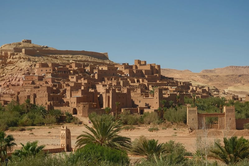 Mud-brick kasbah village on a desert hillside, southern Morocco